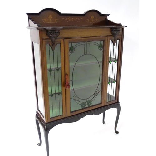 1711 - An Edwardian mahogany display cabinet with leaded glass panelling, stained glass panels and a satinw... 