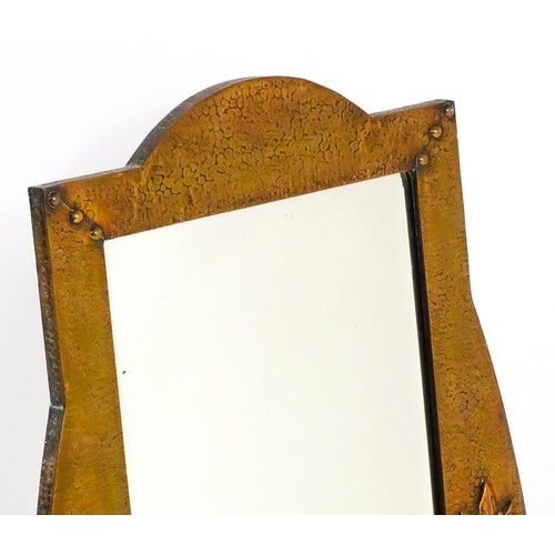 1713 - An Arts & Crafts style hammered coppered mirror with rivet detailing and a bevelled glass. 19