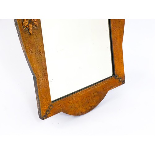 1713 - An Arts & Crafts style hammered coppered mirror with rivet detailing and a bevelled glass. 19