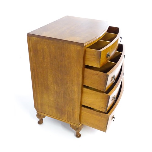 1733 - An Art Deco style walnut chest of drawers with a bowed front and four long drawers raised on four ca... 