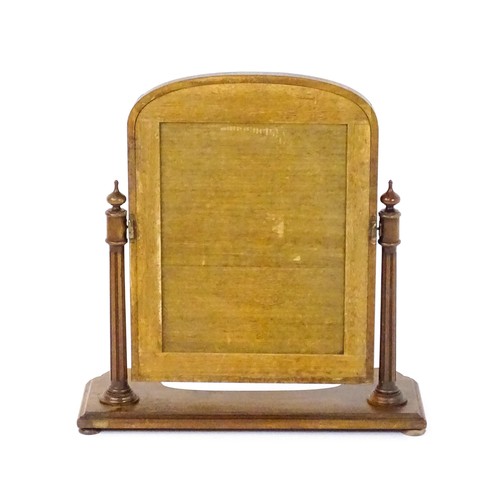 1734 - A 19thC mahogany toilet mirror with an arched frame, fluted supports with turned finial terminals an... 