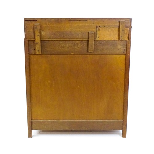 1736 - An Arts & Crafts oak cabinet with an upstand above a single short drawer and two panelled doors and ... 