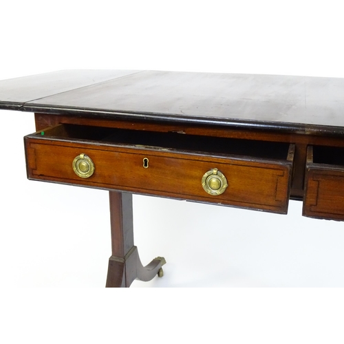 1745 - A Regency rosewood sofa table with ebonised stringing to the top and drop flaps to either side, the ... 