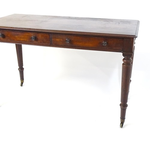 1747 - An early 19thC mahogany two drawer writing desk, having a moulded top above two short drawers with t... 