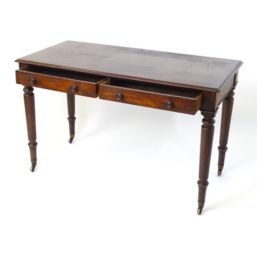 1747 - An early 19thC mahogany two drawer writing desk, having a moulded top above two short drawers with t... 