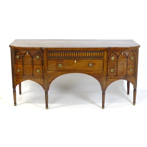 1752 - An early / mid 19thC mahogany Gothic sideboard, having a D-shaped top above lancet mouldings and rin... 