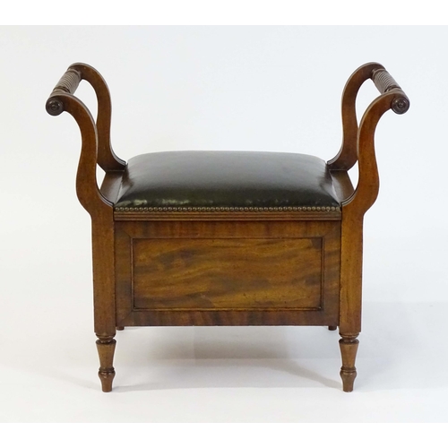 1753 - An early / mid 19thC mahogany piano stool / window seat with a lifting leather upholstered seat flan... 