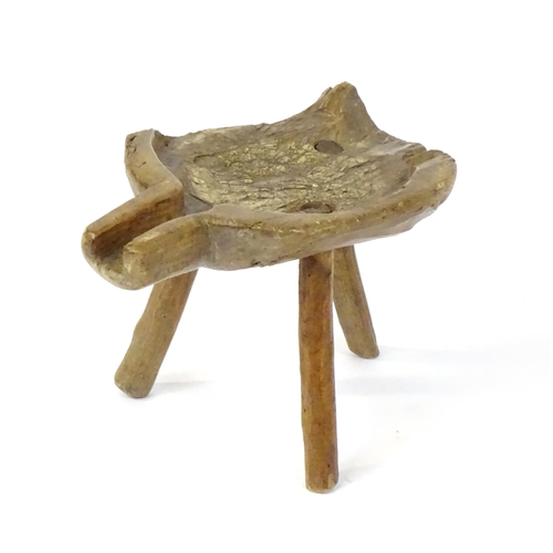 1756 - A late 18thC elm cheese stool, with a shaped top, spout and raised on three turned legs. 10