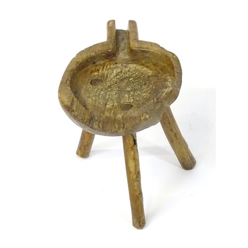 1756 - A late 18thC elm cheese stool, with a shaped top, spout and raised on three turned legs. 10