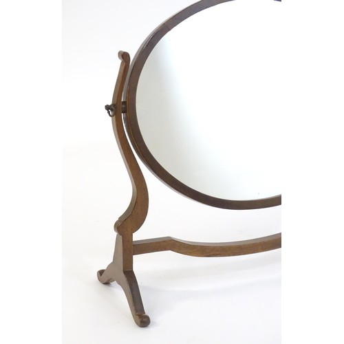 1757 - A Victorian mahogany skeleton / toilet mirror of oval farm, having shaped supports and raised on cab... 