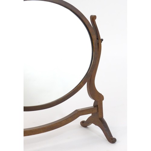 1757 - A Victorian mahogany skeleton / toilet mirror of oval farm, having shaped supports and raised on cab... 