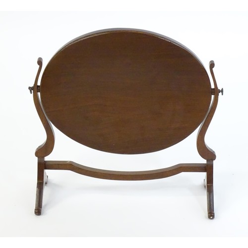 1757 - A Victorian mahogany skeleton / toilet mirror of oval farm, having shaped supports and raised on cab... 