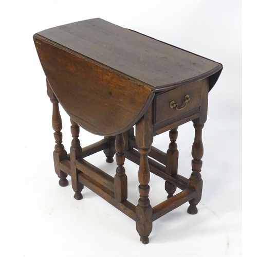 1758 - An 18thC oak gateleg table open to form an oval table top above a peg jointed bae and with block and... 