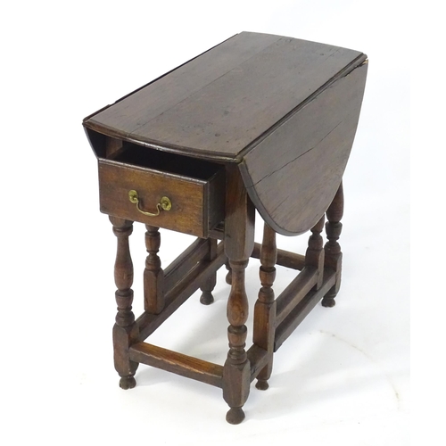 1758 - An 18thC oak gateleg table open to form an oval table top above a peg jointed bae and with block and... 