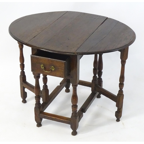 1758 - An 18thC oak gateleg table open to form an oval table top above a peg jointed bae and with block and... 