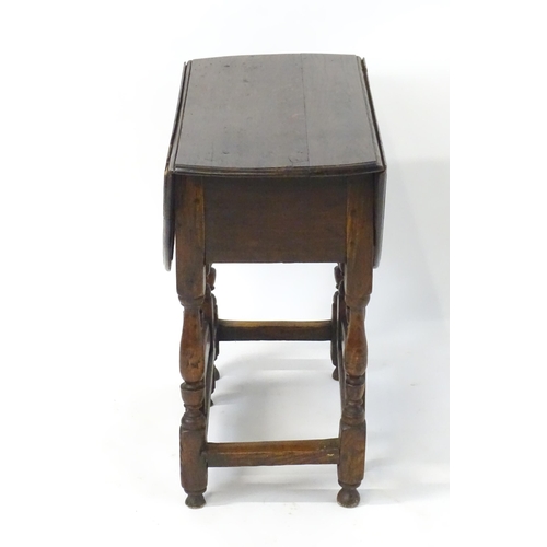 1758 - An 18thC oak gateleg table open to form an oval table top above a peg jointed bae and with block and... 