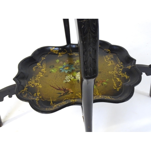 1762 - A 19thC ebonised table with two papier machete tiers. both tiers formed from tray tops and having ha... 