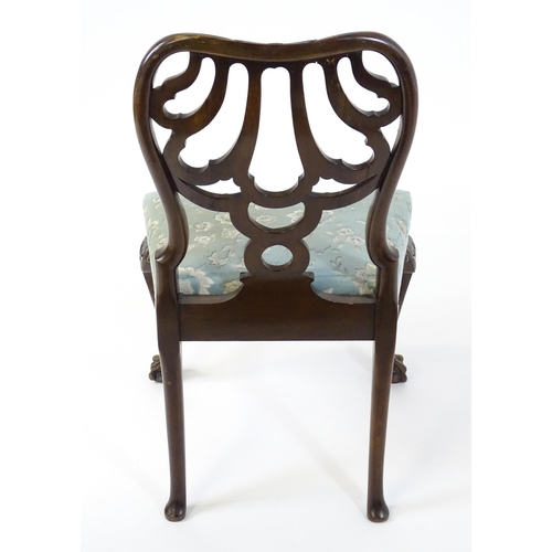 1763 - A Victorian mahogany Chippendale style side chair, having a carved, pierced backrest and raised on c... 