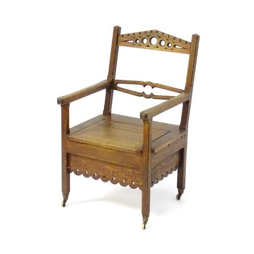 1765 - An Arts and Crafts style oak chair, having a pierced pointed top rail and shaped mid rail above a hi... 