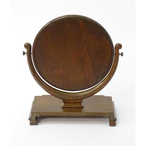 1770 - A 19thC mahogany toilet mirror with circular glass supported by shaped, scrolled and reeded supports... 