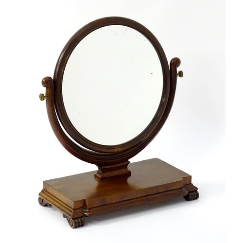 1770 - A 19thC mahogany toilet mirror with circular glass supported by shaped, scrolled and reeded supports... 