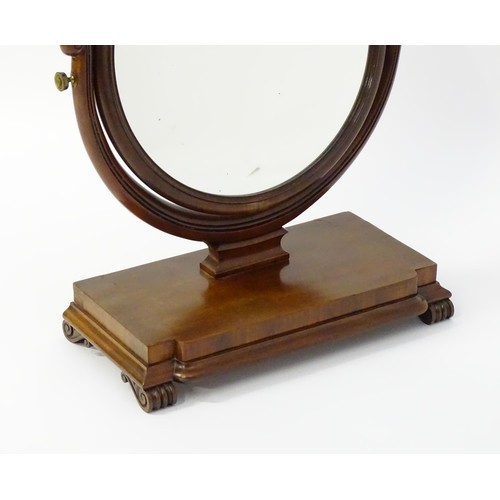 1770 - A 19thC mahogany toilet mirror with circular glass supported by shaped, scrolled and reeded supports... 