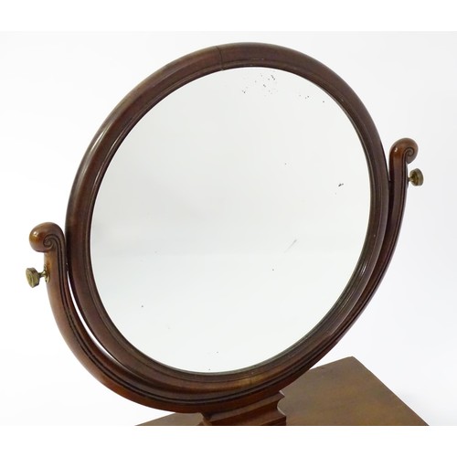 1770 - A 19thC mahogany toilet mirror with circular glass supported by shaped, scrolled and reeded supports... 