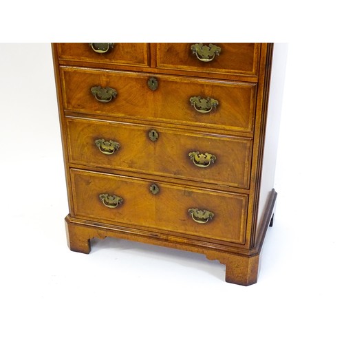 1776 - A George II style walnut record cabinet. with a crossbanded and hinged top above feather banded faux... 