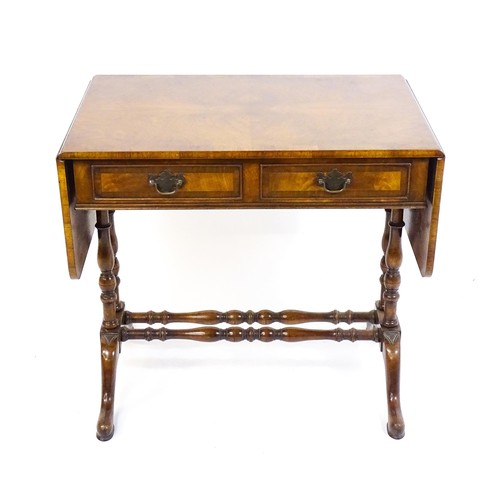 1777 - A 20thC walnut sofa table with a crossbanded top, drop leaves, and two frieze drawers. The top raise... 