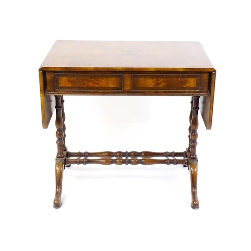 1777 - A 20thC walnut sofa table with a crossbanded top, drop leaves, and two frieze drawers. The top raise... 