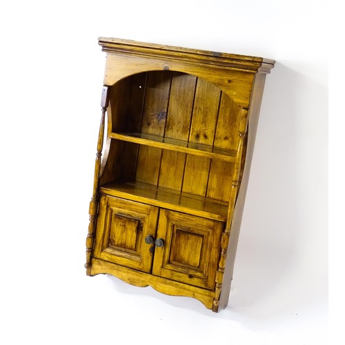 1778 - A small wall hanging cabinet of pine construction, with a moulded cornice above two shelves and two ... 