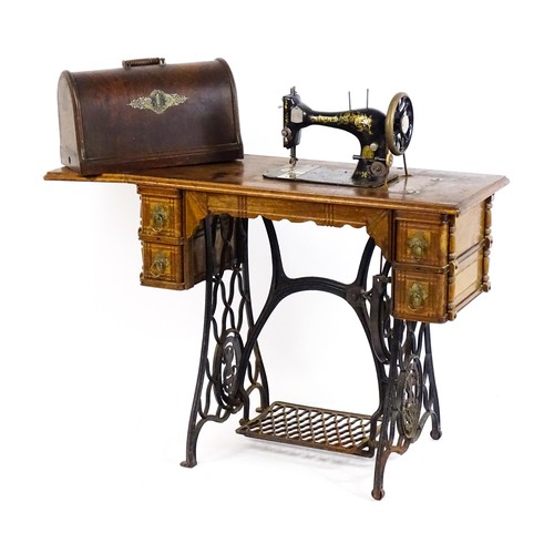 1784 - An early 20thC singer sewing machine mounted upon a table, with four short drawers, a drop flap and ... 