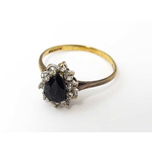 618 - A 9ct gold ring set with central blue stone bordered by white stones. Ring size approx. L 1/2