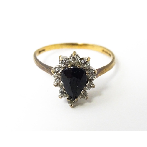 618 - A 9ct gold ring set with central blue stone bordered by white stones. Ring size approx. L 1/2