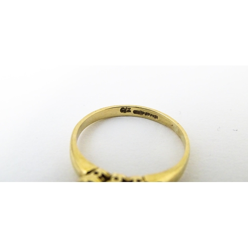 620 - A 9ct gold ring set with a trio cubic zirconia. Ring size approx. N 1/2