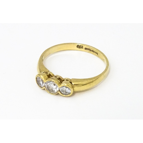 620 - A 9ct gold ring set with a trio cubic zirconia. Ring size approx. N 1/2