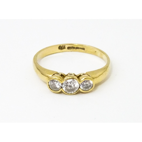 620 - A 9ct gold ring set with a trio cubic zirconia. Ring size approx. N 1/2