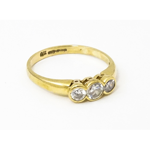 620 - A 9ct gold ring set with a trio cubic zirconia. Ring size approx. N 1/2