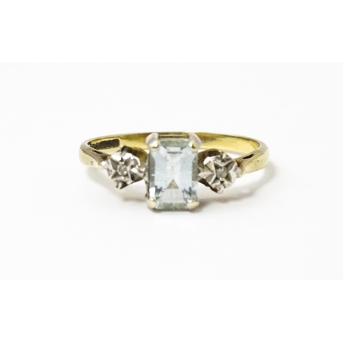 621 - A 9ct gold ring set with central aquamarine flanked by illusion set diamonds. Ring size approx. I 1/... 