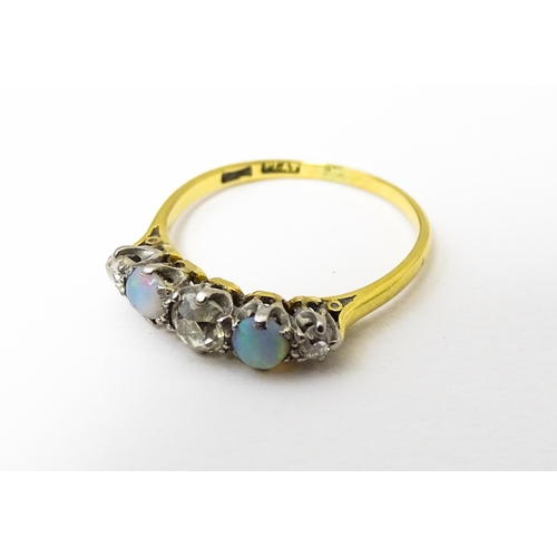 623 - An 18ct ring set with two opals and three diamonds. Ring size approx. O 1/2