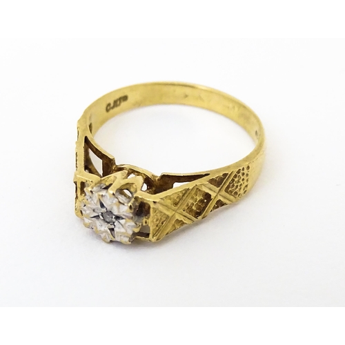 625 - A 9ct gold ring set with an illusion set diamond with engraved detail to shoulders. Ring size approx... 