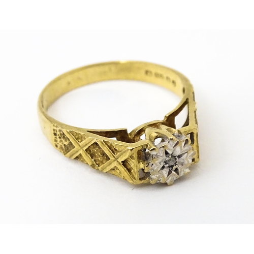 625 - A 9ct gold ring set with an illusion set diamond with engraved detail to shoulders. Ring size approx... 