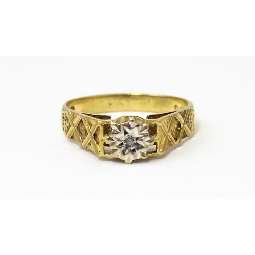 625 - A 9ct gold ring set with an illusion set diamond with engraved detail to shoulders. Ring size approx... 