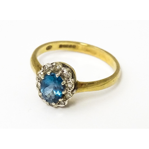 626 - A 9ct ring set with central topaz bordered by diamonds. Ring size approx. M 1/2