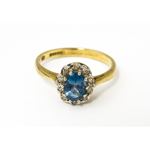 626 - A 9ct ring set with central topaz bordered by diamonds. Ring size approx. M 1/2