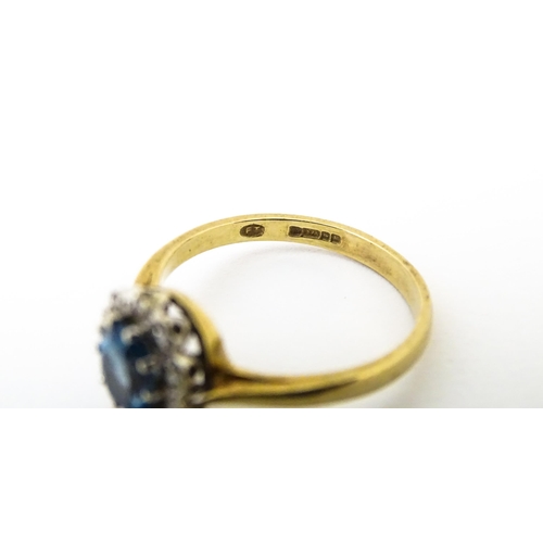 626 - A 9ct ring set with central topaz bordered by diamonds. Ring size approx. M 1/2