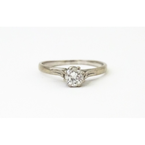 627 - A white metal ring set with central diamond solitaire. Diamond approx. 1/8