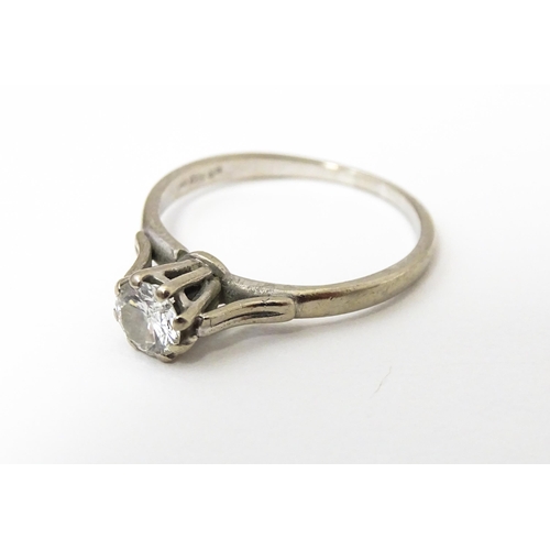 627 - A white metal ring set with central diamond solitaire. Diamond approx. 1/8