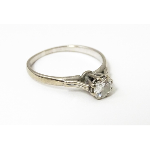 627 - A white metal ring set with central diamond solitaire. Diamond approx. 1/8