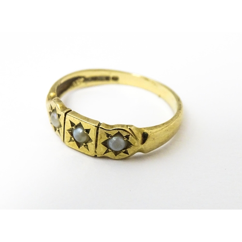 628 - A 9ct gold ring set with three seed pearls. Ring size approx. M